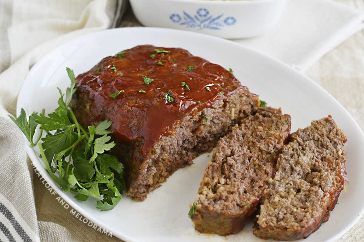 mom's onion soup meatloaf cut open on a white platter with parsley