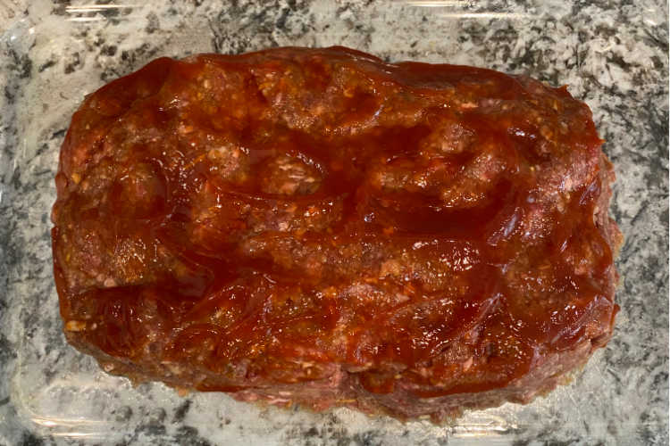 meatloaf topped with ketchup in glass baking dish