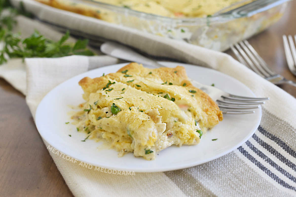 chicken pot pie with crescent roll crust on a white plate