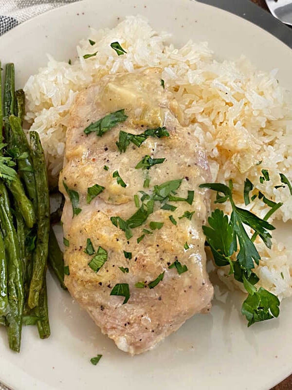 boneless crock pot pork chop on plate with green beans and rice