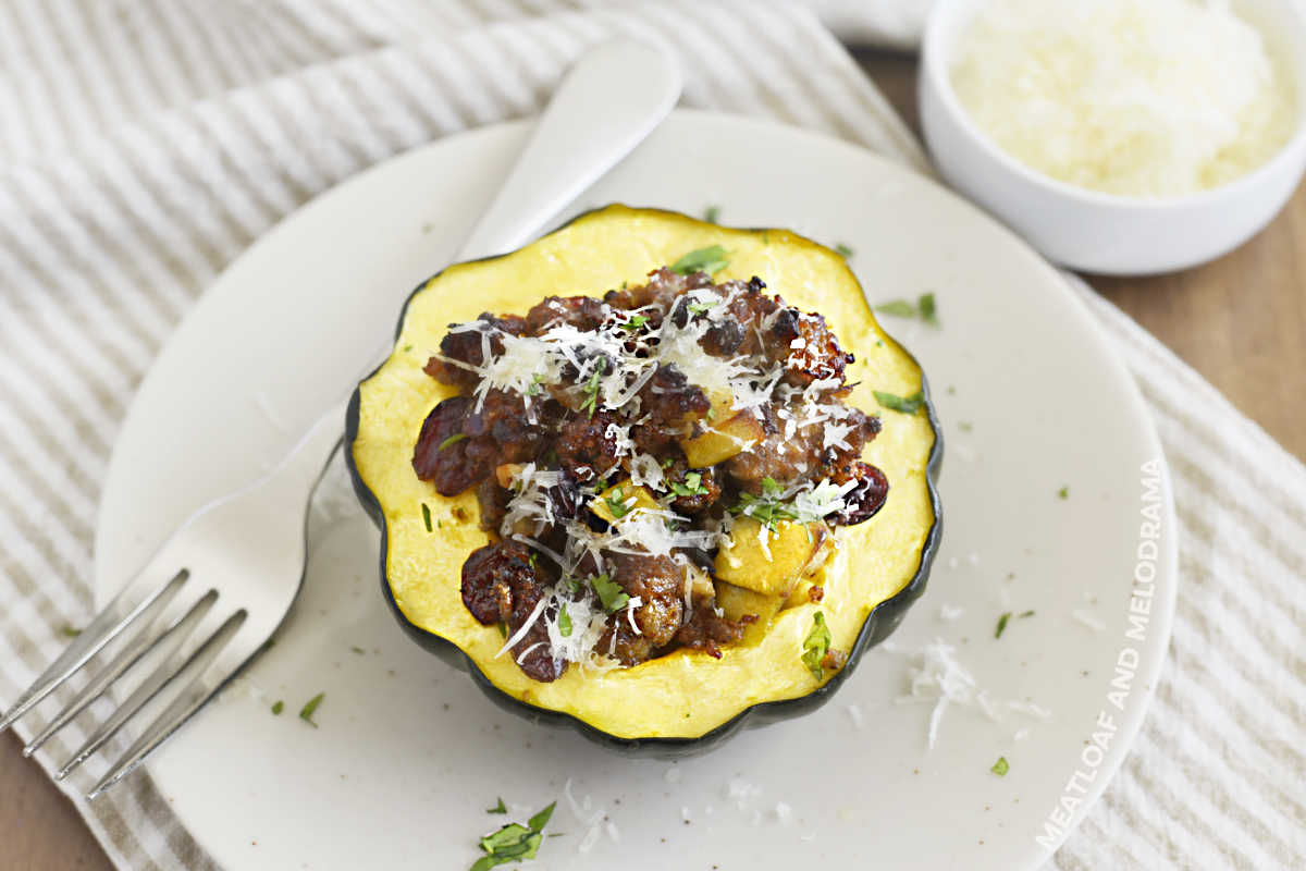 sausage stuffed acorn squash with apples and cranberries on a plate