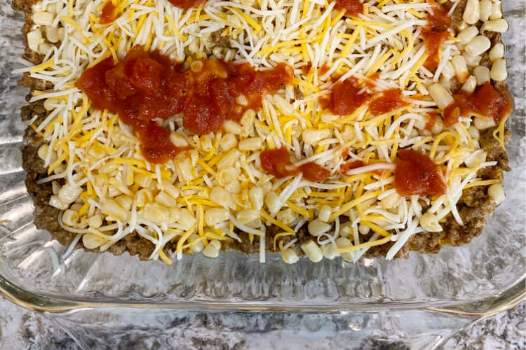 taco meat in baking dish with cheese and salsa on top