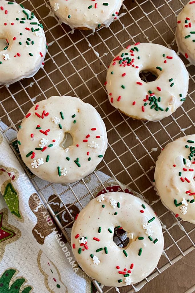 glazed eggnog donuts with sprinkles on baking rack
