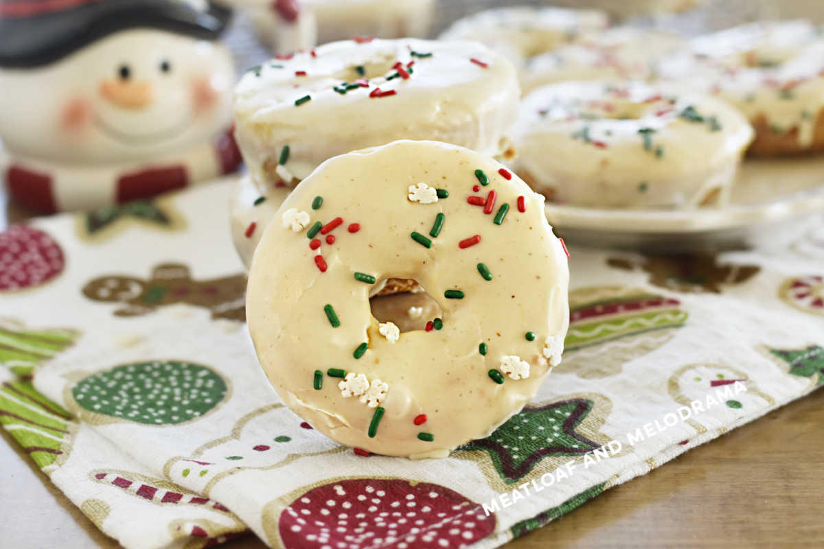 baked eggnog donuts with glaze and red and green sprinkles on the table