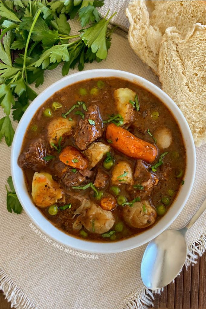 bowl of  beef burgundy with carrots, peas and potatoes with parsely