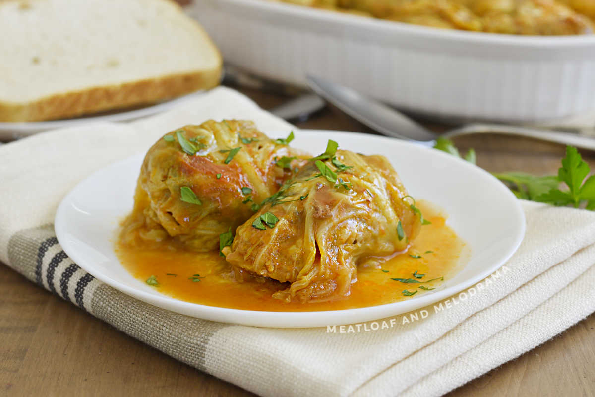 2 stuffed cabbage rolls (halupki) in tomato soup sauce on a white plate