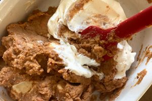 mix refried beans, cream cheese and sour cream in baking dish
