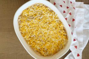 top dip with cheddar cheese in casserole dish