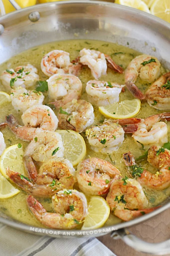 cooked shrimp in garlic butter sauce with lemon and parsley