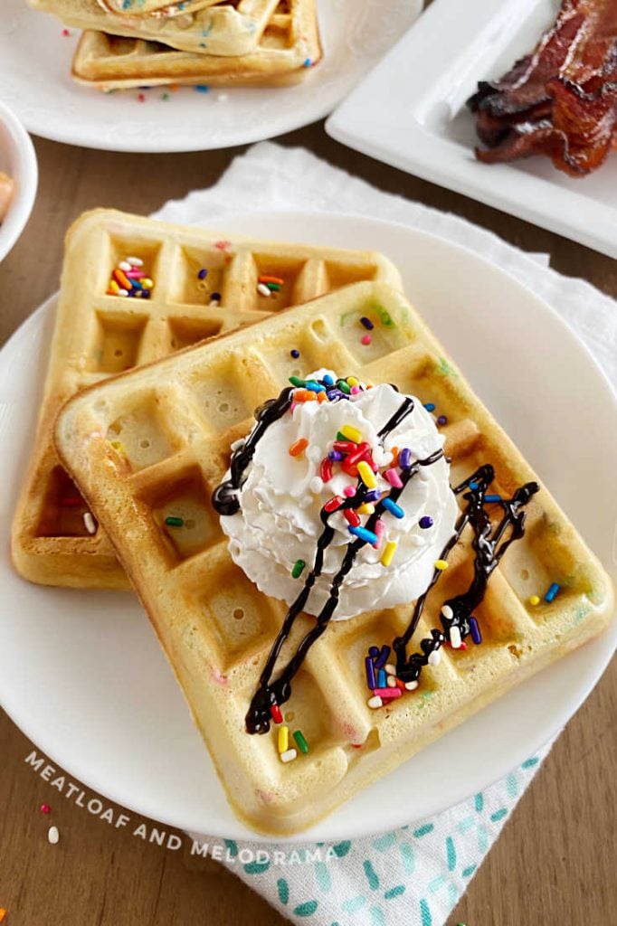 2 birthday waffles with sprinkles and whipped cream on a plate