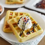 2 funfetti waffles with sprinkles and whipped cream on a plate