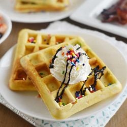 2 funfetti waffles with sprinkles and whipped cream on a plate