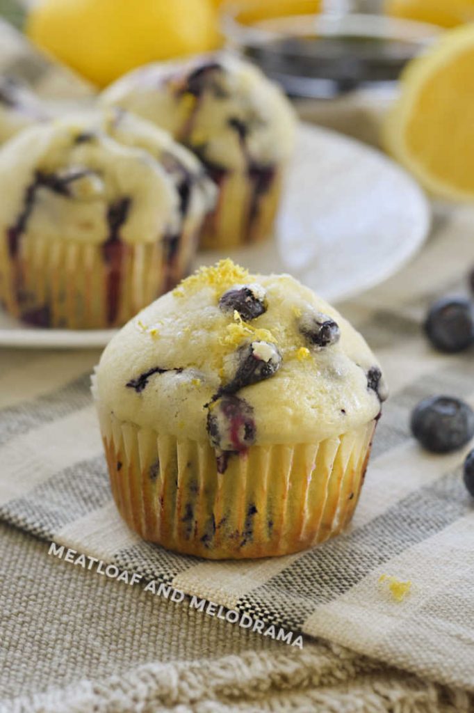 lemon blueberry muffins with lemon zest and glaze on top on the table