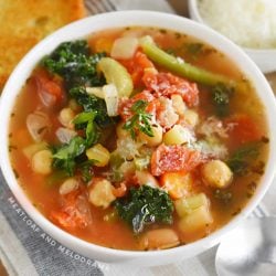 bowl of instant pot minestrone soup with garlic bread and parmesan cheese