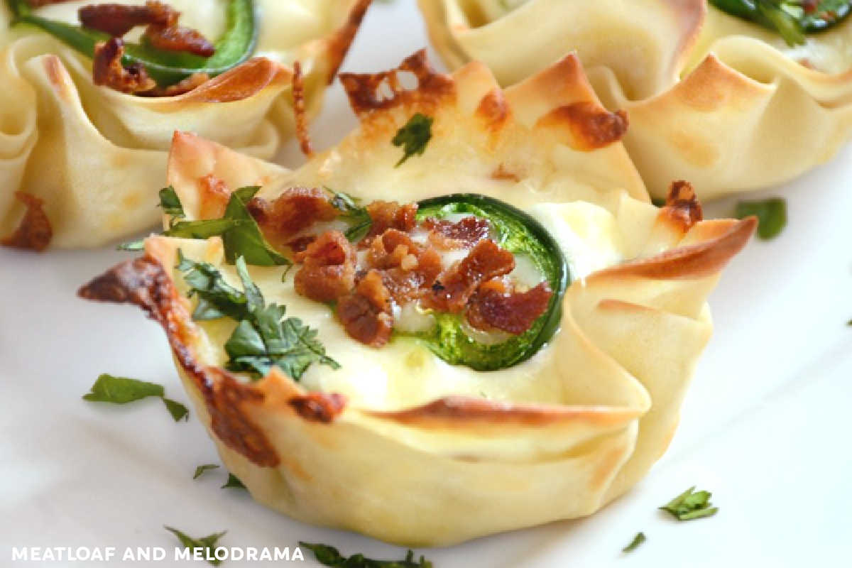 jalapeño popper wonton cups on a plate with cilantro and bacon bits