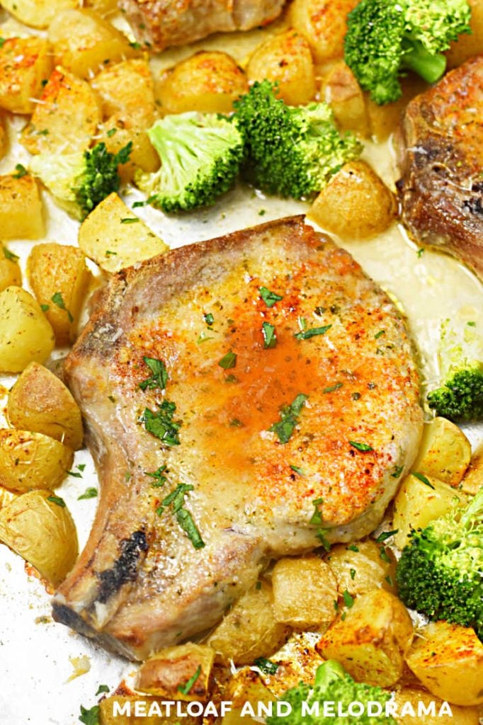 baked pork chop with paprika and potatoes and broccoli on a sheet pan