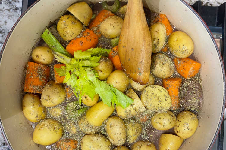 potatoes, carrots, celery and beef chunks in a dutch oven