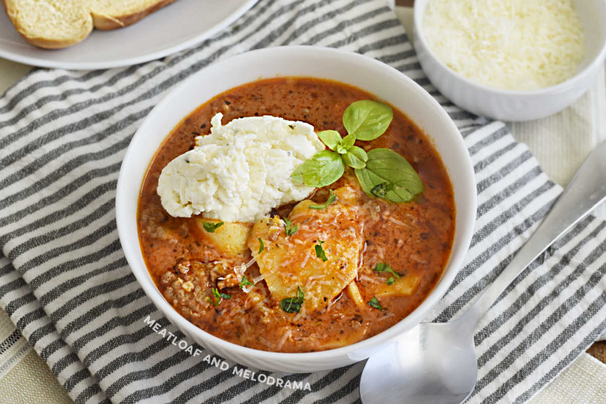 bowl of instant pot lasagna soup with ricotta cheese and basil