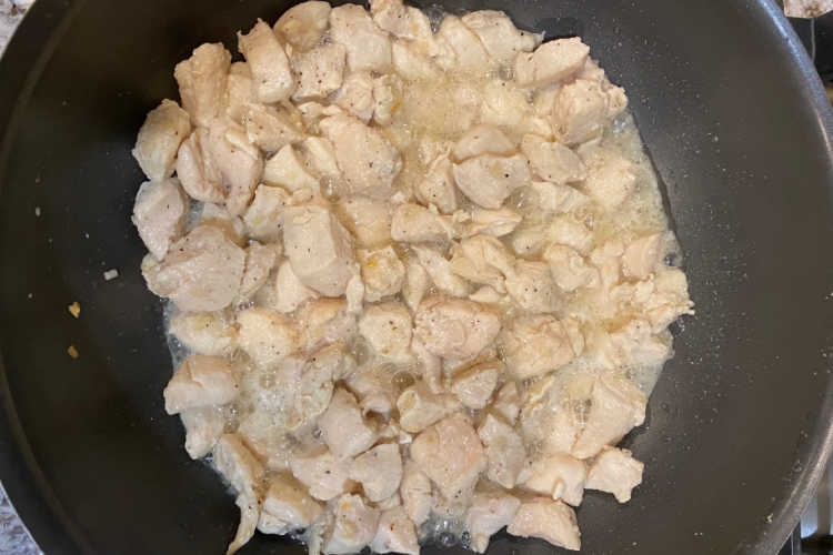 cubed chicken breast in frying pan