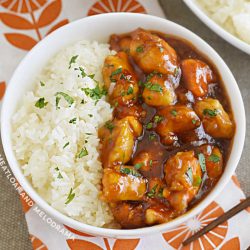 bowl of orange chicken with orange marmalade bbq sauce on the table with rice