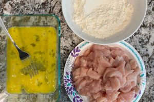 cut chicken breasts with beaten eggs and flour in pans