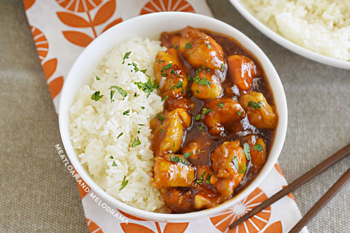 orange chicken with marmalade and bbq sauce in a white bowl with rice
