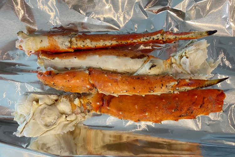 4 crab legs on a sheet of aluminum foil