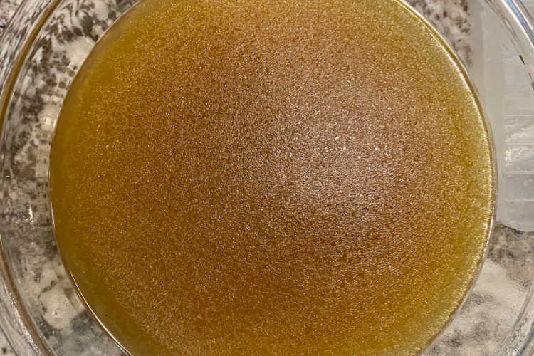 bowl of homemade chicken stock on the counter