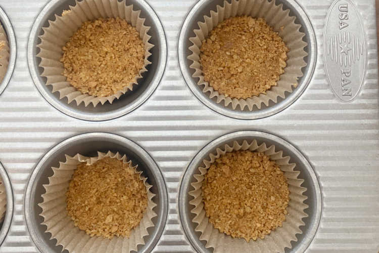crushed graham crackers in muffin tin baking cups