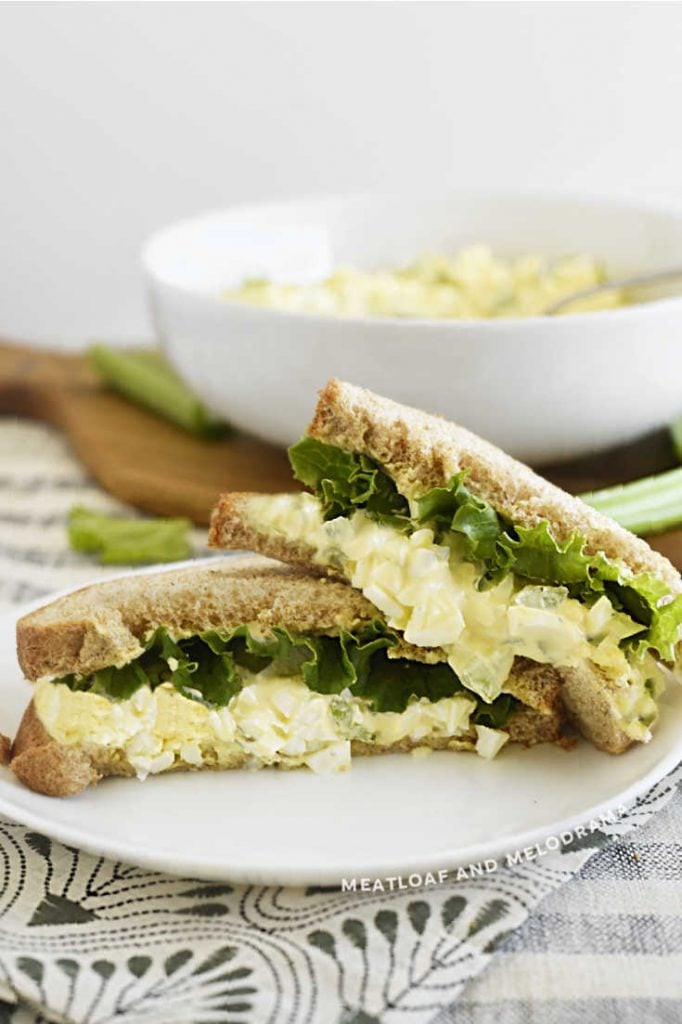 egg salad sandwich on wheat bread with lettuce on a plate