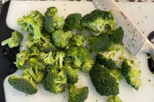 chopped broccoli florets on cutting board