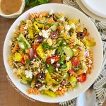 Greek pasta salad with feta cheese in white serving bowl