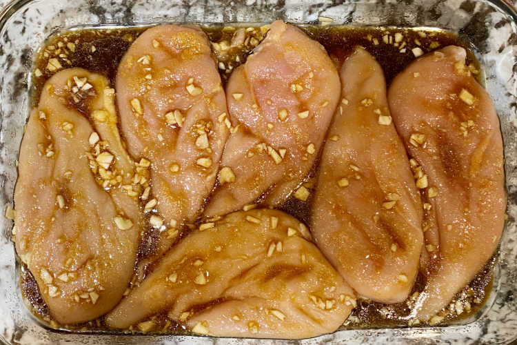 chicken breasts with garlic and honey soy sauce mix in a baking dish