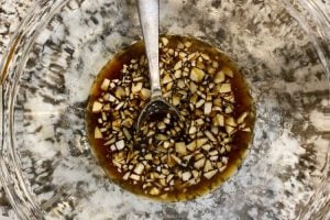 soy sauce, honey and vinegar in mixing bowl with chopped garlic