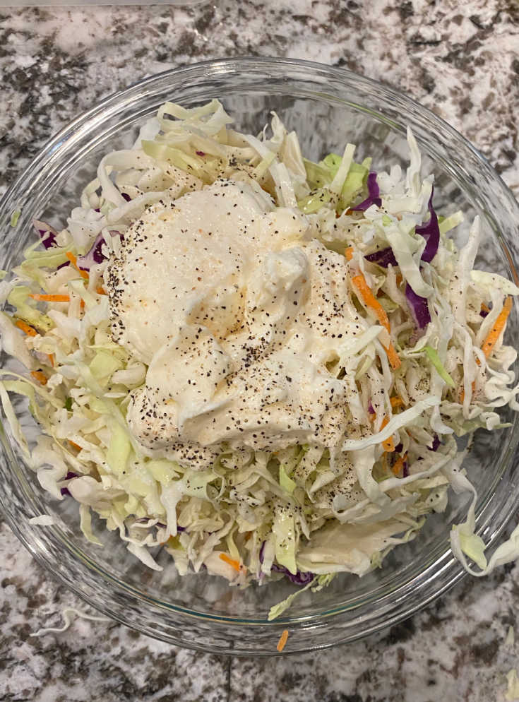 coleslaw mix with mayonnaise in mixing bowl