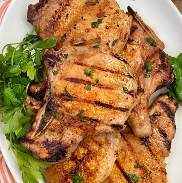 grilled pork chops with Italian marinade on white platter