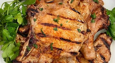 grilled pork chops with Italian marinade on white platter