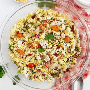 chicken bacon ranch pasta salad with rotini and cheddar and tomatoes in a bowl