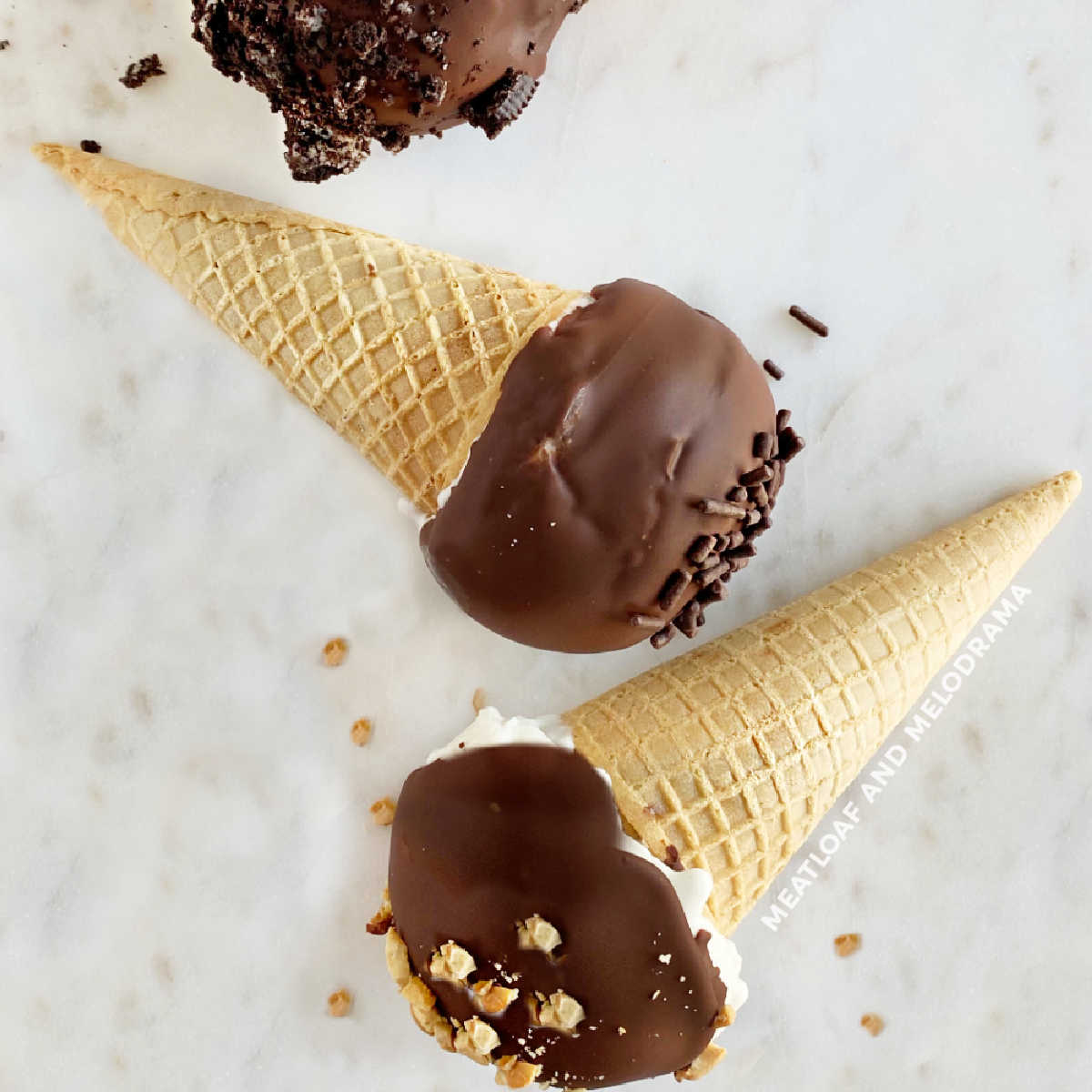 homemade drumsticks ice cream cones with chocolate coating on marble surface
