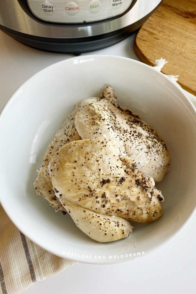 chicken breasts in bowl near instant pot pressure cooker