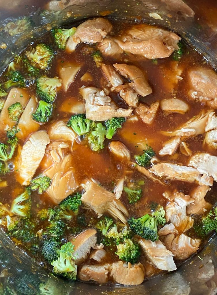 sliced chicken breasts and broccoli in honey garlic sauce in pressure cooker