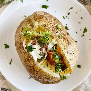 microwave baked potato with broccoli, sour cream, cheese and bacon on a plate