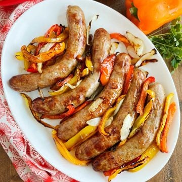 air fryer sausage and peppers with onions on a white serving tray