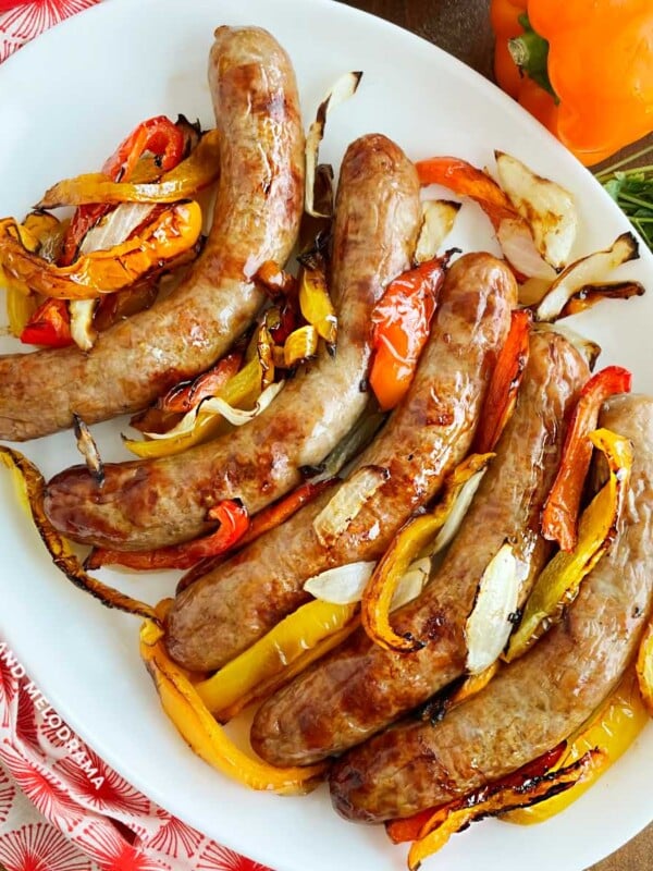 air fryer sausage and peppers with onions on a white serving tray