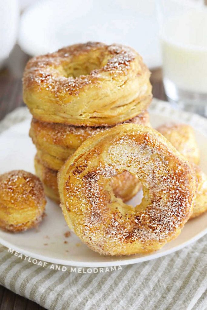 air fryer biscuit donuts coated in cinnamon sugar mixture on white plate