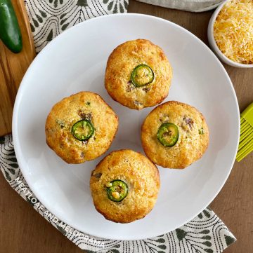plate of jiffy jalapeno sausage cornbread muffins with jalapeno pepper slice on top