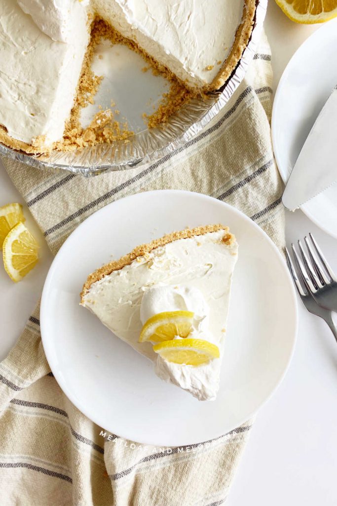 overhead shot of slice of lemonade cool aid pie on a plate with lemon slices