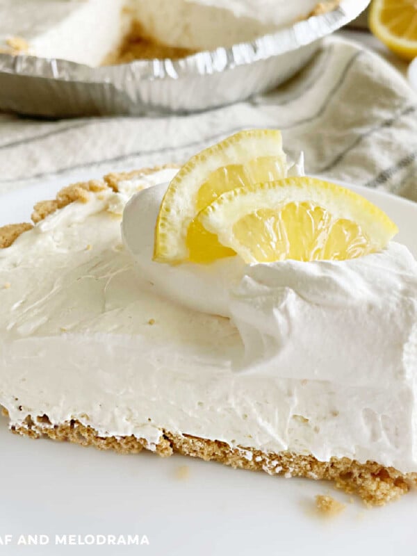 no bake lemonade kool aid pie with lemon slice and graham cracker crust on a white plate
