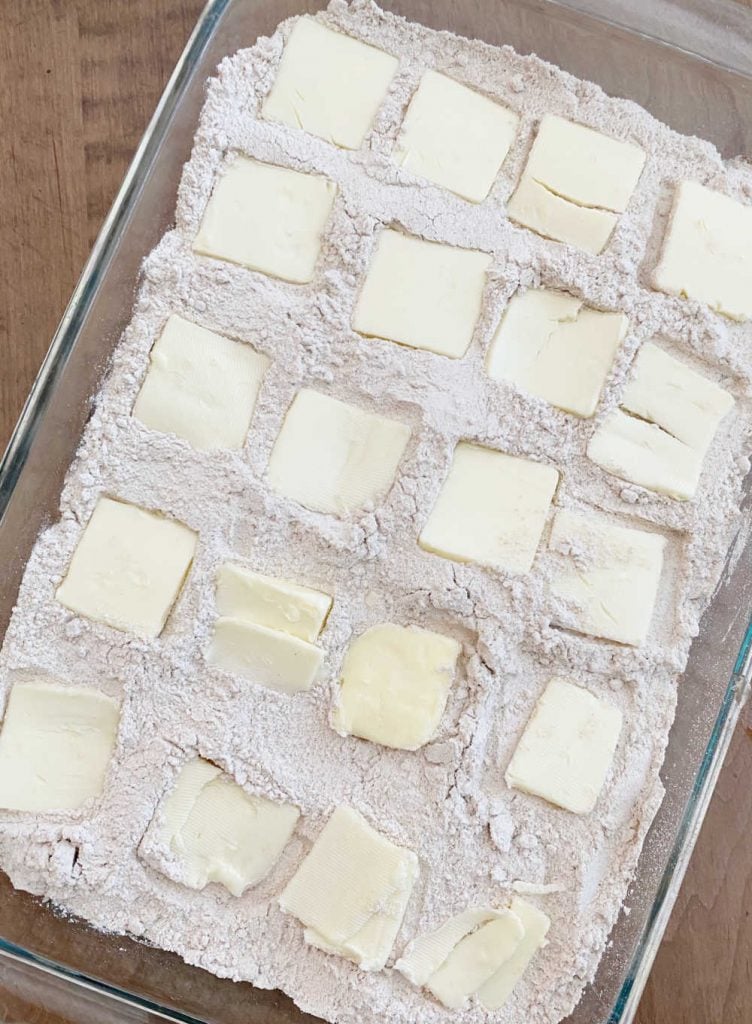 squares of butter over spice cake mix in baking dish
