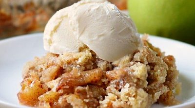 apple crisp without oats on a plate with vanilla ice cream on top